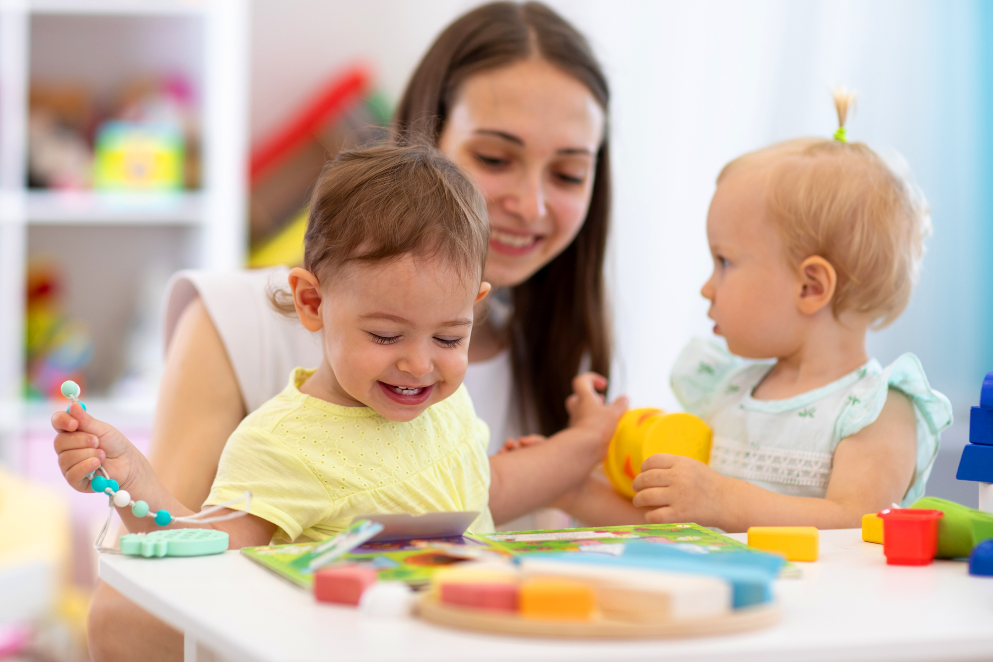 young children playing with teacher in daycare setting