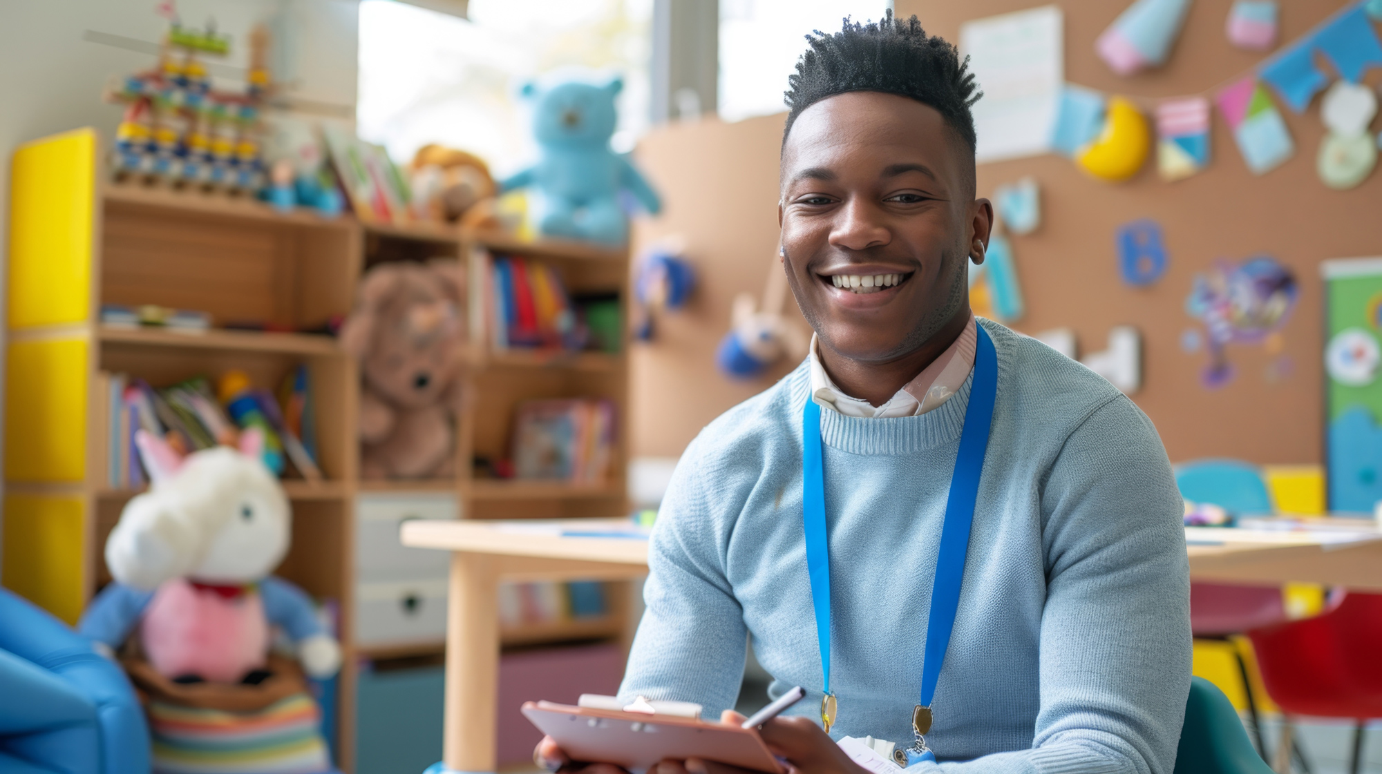The cheerful young male teacher in a preschool setting